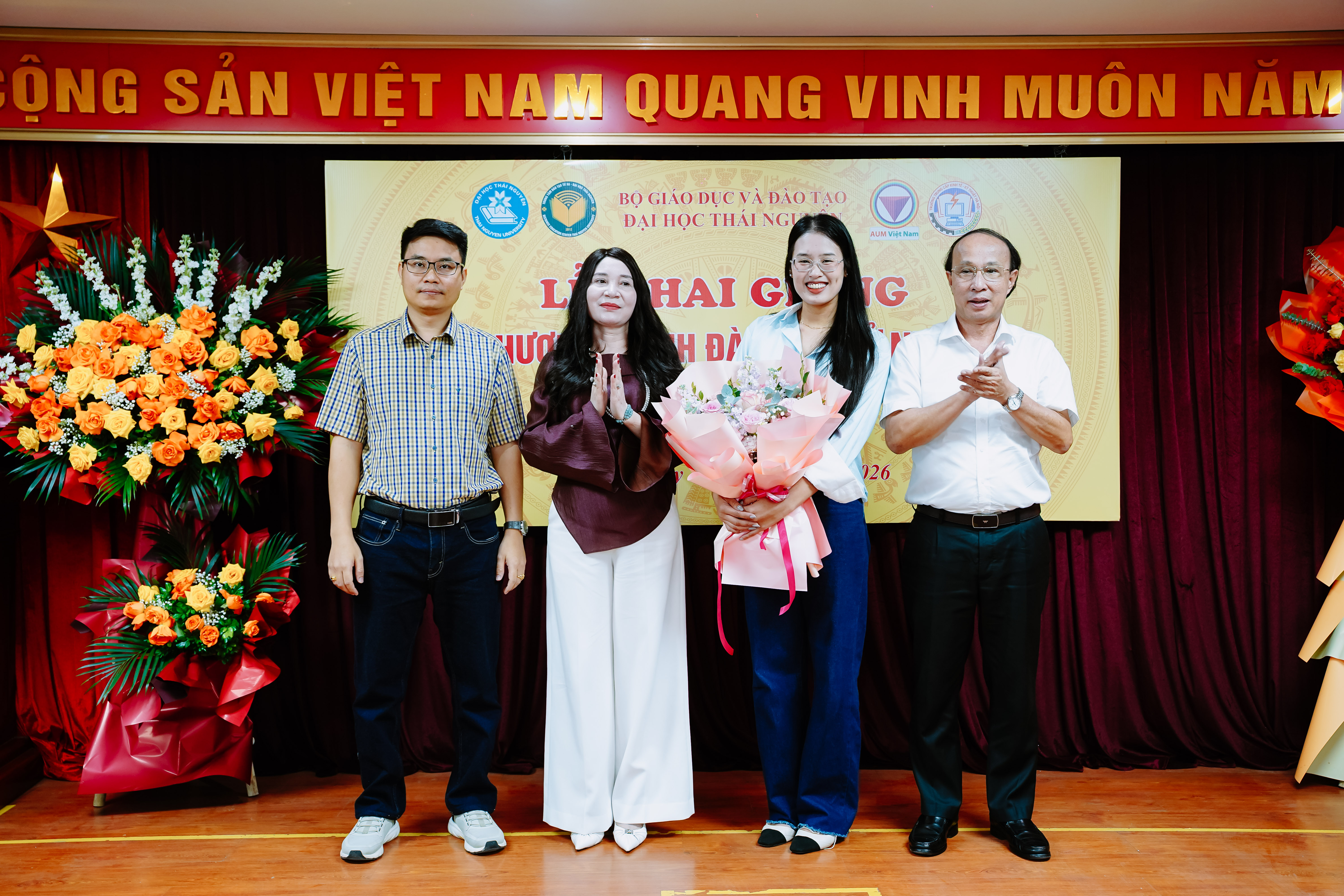 Đại diện ba đơn vị tặng hoa ch&uacute;c mừng đại diện T&acirc;n học vi&ecirc;n
